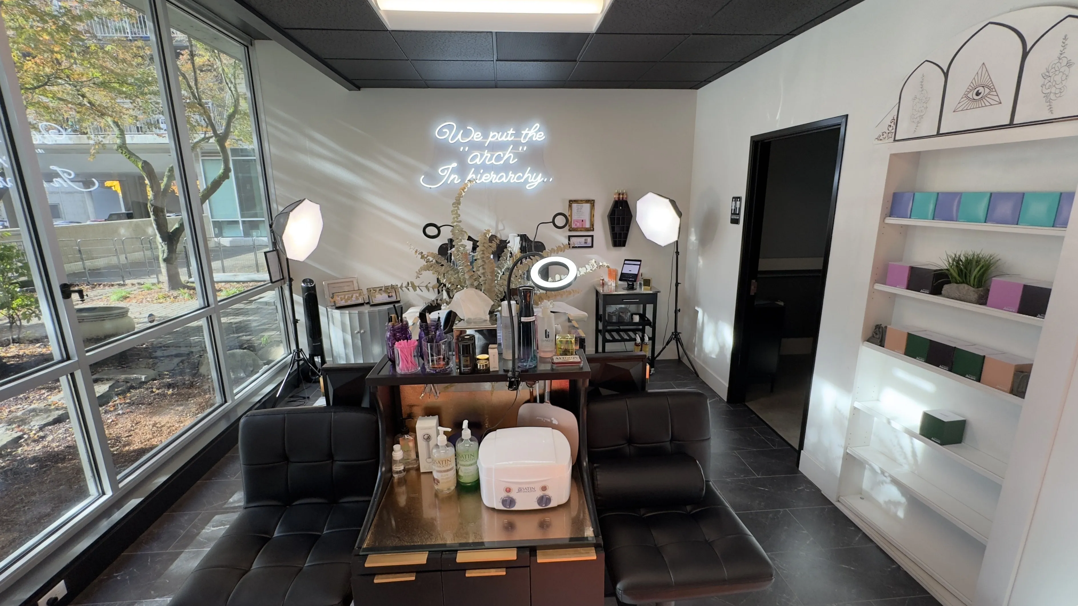 A neon sign that says 'We Put the Arch in Hierarchy' over an immaculate salon